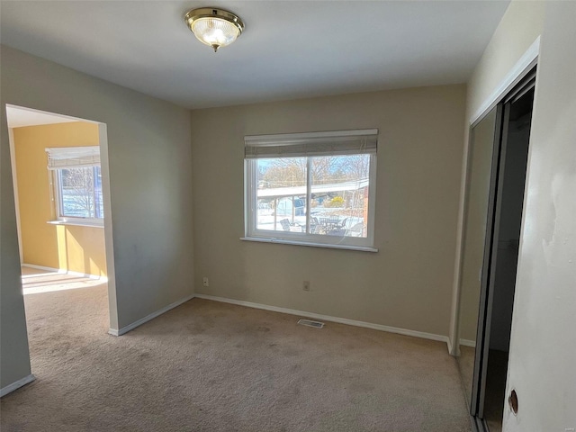 unfurnished bedroom with a closet, visible vents, baseboards, and carpet