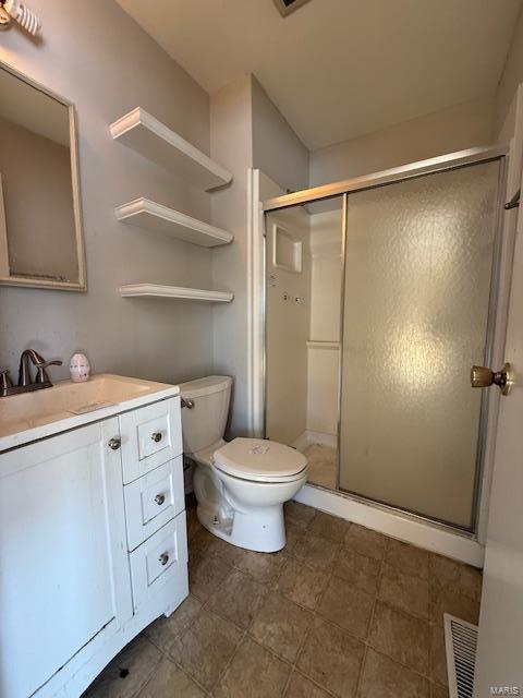 full bath featuring vanity, a shower stall, toilet, and visible vents