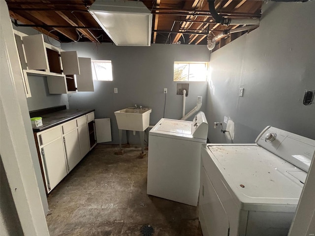 clothes washing area with washer and dryer and a sink