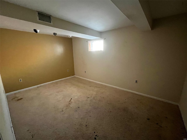 basement featuring visible vents, baseboards, and carpet floors