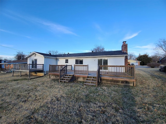 rear view of property with a wooden deck, a yard, and a chimney