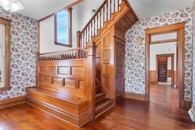 stairs featuring hardwood / wood-style floors and a textured ceiling