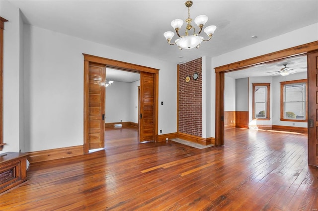 unfurnished room featuring hardwood / wood-style floors and ceiling fan with notable chandelier