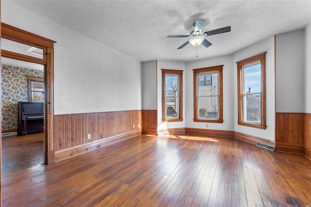 unfurnished room featuring ceiling fan, a textured ceiling, and dark hardwood / wood-style flooring