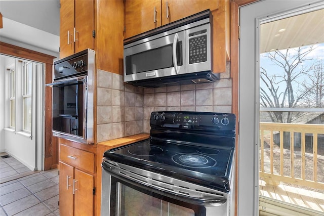 kitchen featuring tasteful backsplash, light tile patterned flooring, and appliances with stainless steel finishes