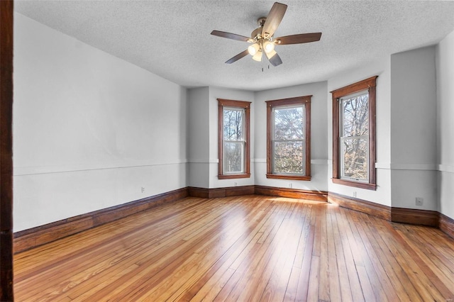 unfurnished room with ceiling fan, wood-type flooring, and a textured ceiling