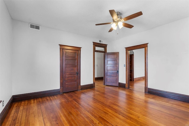 unfurnished bedroom featuring ceiling fan and dark hardwood / wood-style flooring