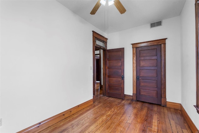 empty room with dark hardwood / wood-style floors and ceiling fan