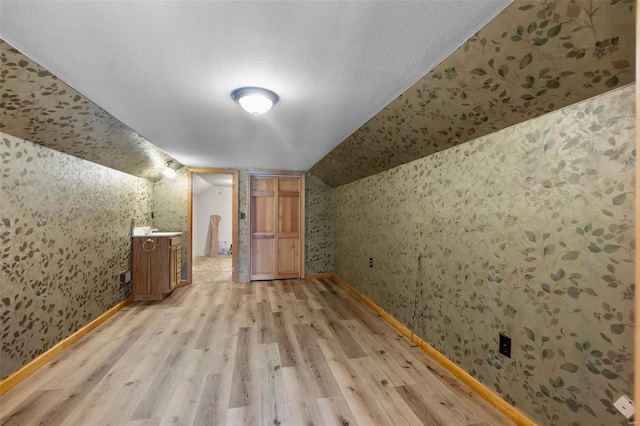 bonus room with light hardwood / wood-style floors and lofted ceiling