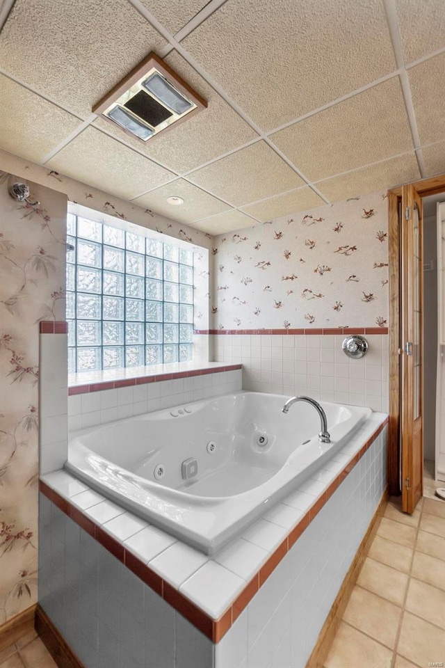 bathroom with tile patterned floors and a relaxing tiled tub