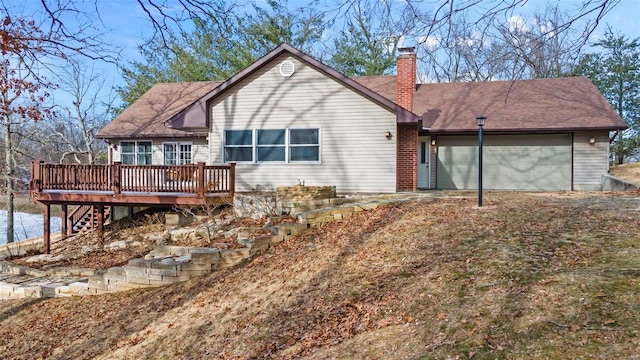 back of house with a garage and a wooden deck