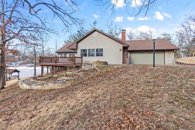 back of house featuring a garage and a wooden deck