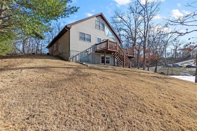 back of house featuring a deck and a lawn