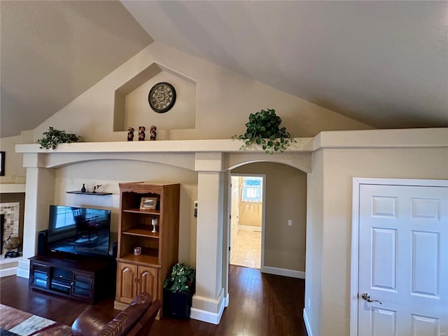 living room with dark wood-type flooring and vaulted ceiling