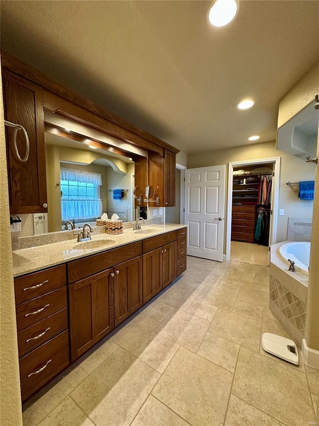 bathroom featuring vanity and tiled bath