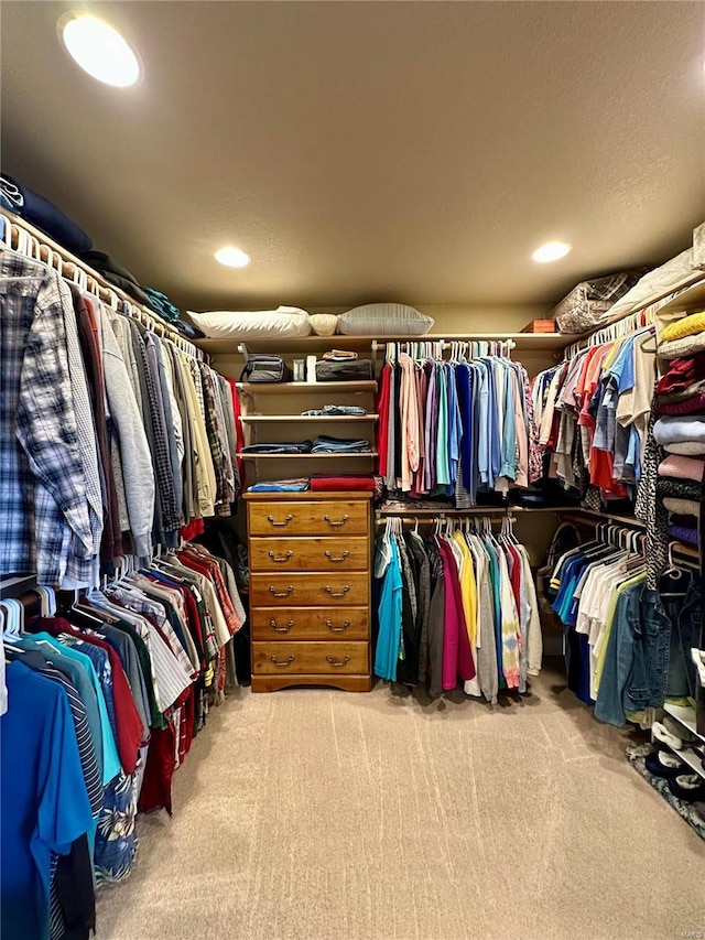 walk in closet featuring light carpet