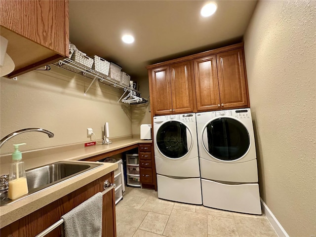 laundry area featuring cabinets, washing machine and dryer, and sink