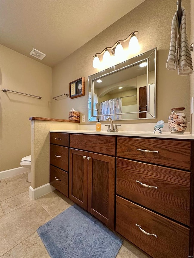 bathroom featuring vanity, curtained shower, and toilet