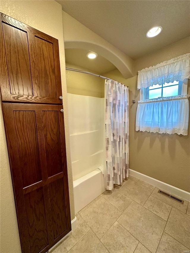 bathroom with shower / bath combo with shower curtain