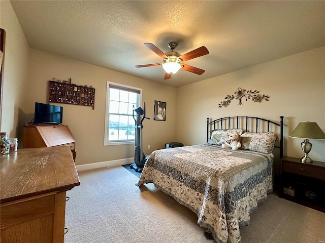 bedroom featuring light carpet, a textured ceiling, and ceiling fan