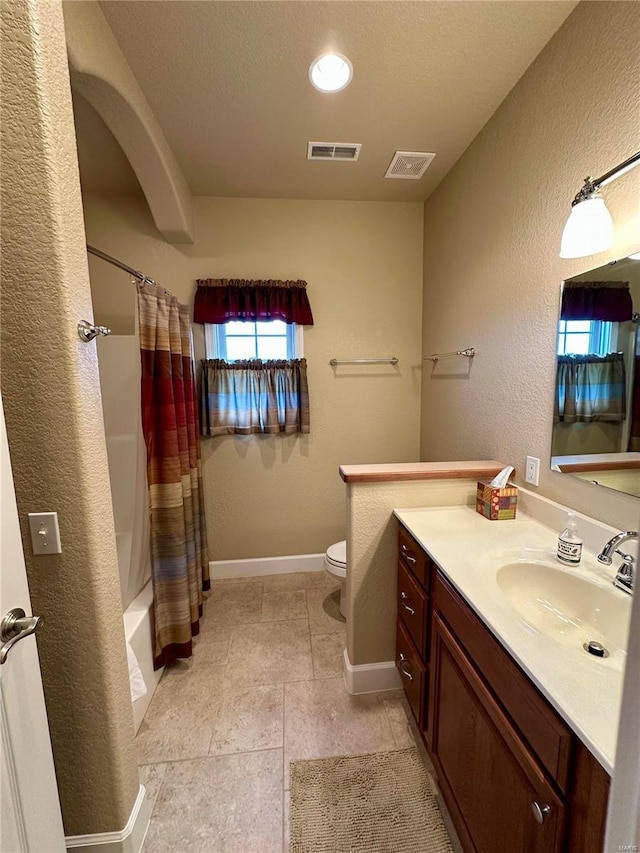 full bathroom with vanity, shower / tub combo with curtain, and toilet