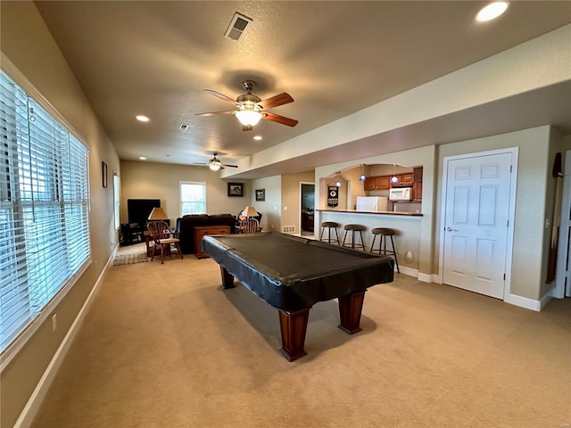 rec room with light carpet, pool table, ceiling fan, and bar area