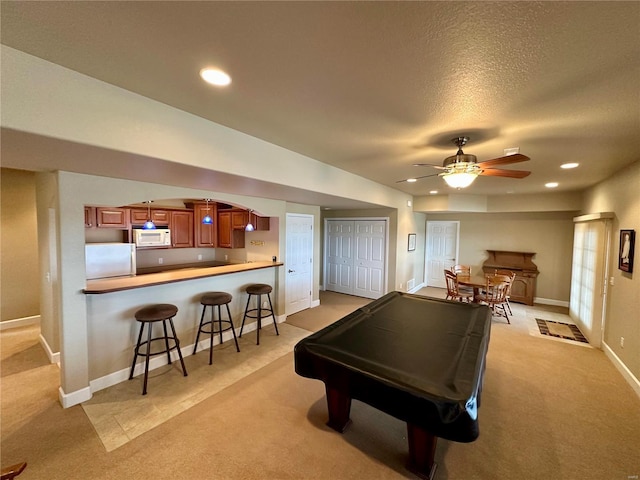 playroom featuring ceiling fan, light carpet, and a textured ceiling