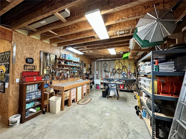 miscellaneous room featuring a workshop area and concrete floors