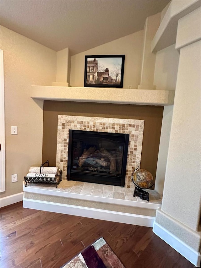 room details with hardwood / wood-style floors and a tile fireplace