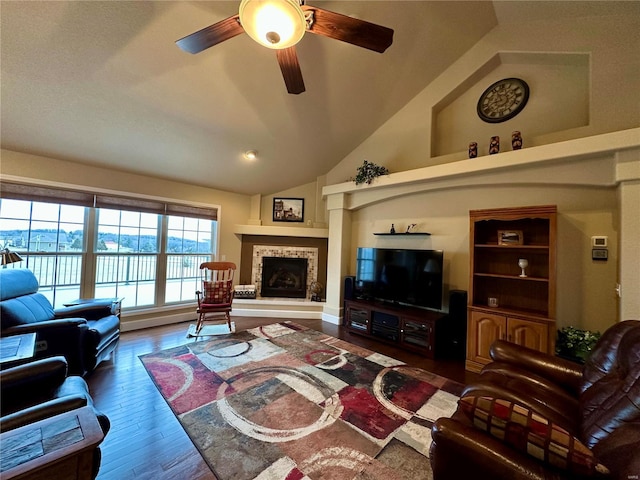 living room with ceiling fan, lofted ceiling, dark hardwood / wood-style flooring, and a tile fireplace