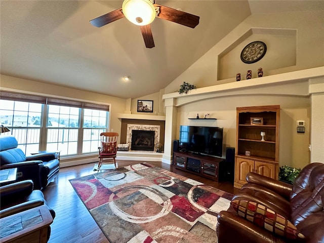 living room featuring ceiling fan, lofted ceiling, dark hardwood / wood-style flooring, and a tiled fireplace