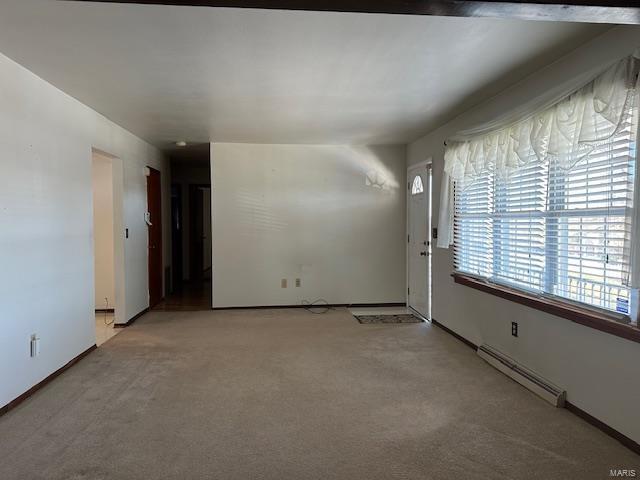 carpeted empty room with a baseboard heating unit