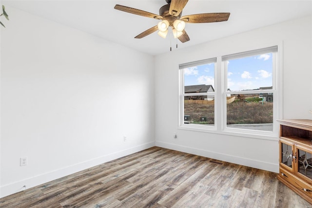 unfurnished room featuring wood-type flooring, a wealth of natural light, and ceiling fan