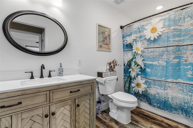 bathroom with hardwood / wood-style flooring, toilet, and vanity