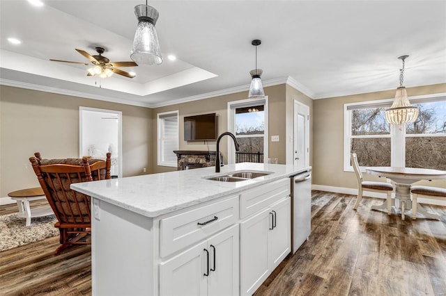 kitchen with white cabinets, dark wood-type flooring, sink, hanging light fixtures, and a tray ceiling