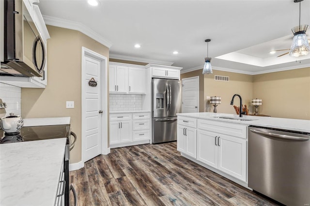 kitchen with backsplash, appliances with stainless steel finishes, sink, and white cabinetry