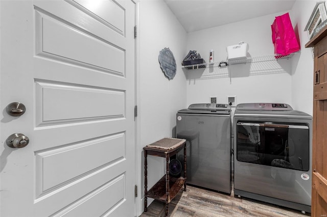 clothes washing area featuring washer and dryer and hardwood / wood-style flooring