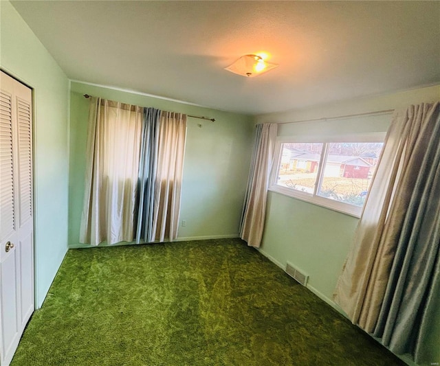 interior space featuring carpet floors, a closet, visible vents, and baseboards