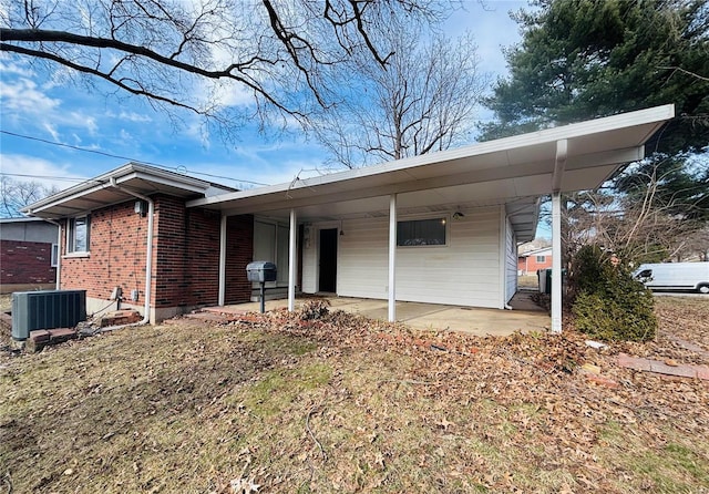 view of front of house featuring central AC unit and brick siding