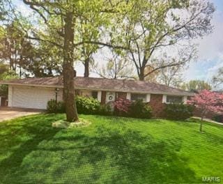 ranch-style home with concrete driveway, an attached garage, and a front lawn