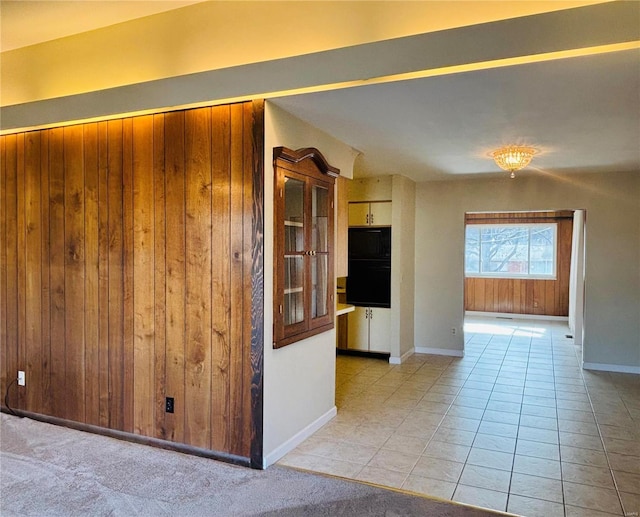 tiled spare room with wooden walls and baseboards