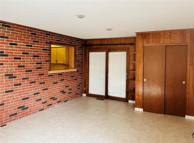 spare room featuring visible vents and brick wall