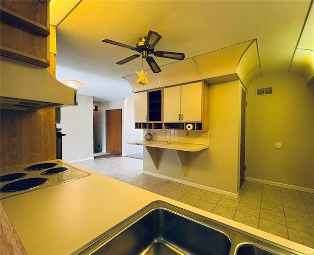 kitchen featuring white electric stovetop, visible vents, baseboards, ceiling fan, and open shelves