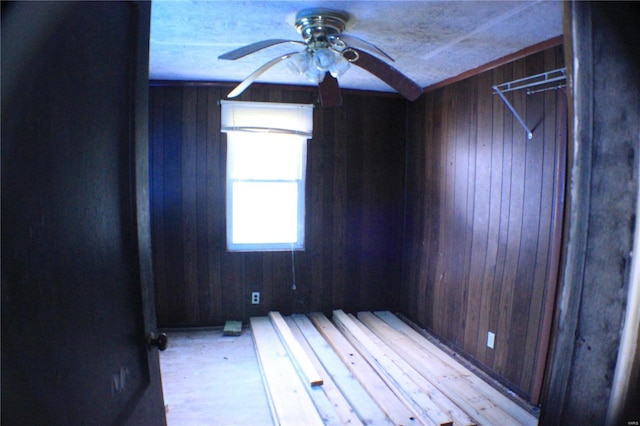 empty room with ceiling fan and wooden walls