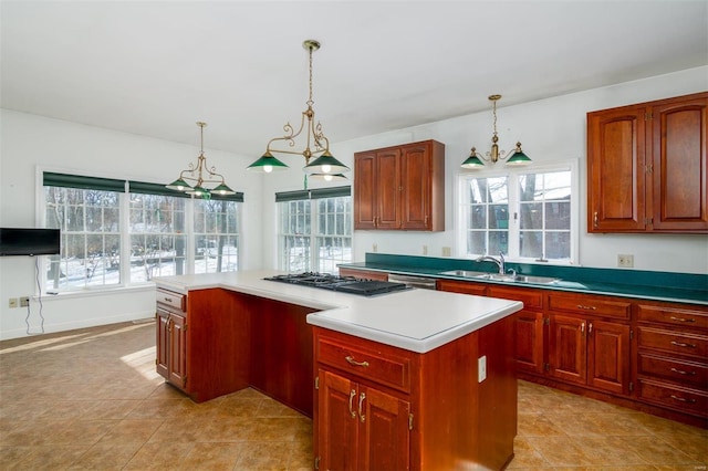 kitchen with dishwasher, hanging light fixtures, sink, a kitchen island, and light tile patterned flooring