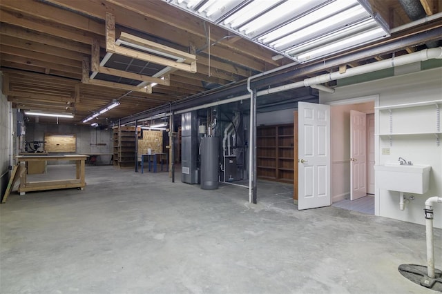 basement featuring sink, water heater, and heating unit