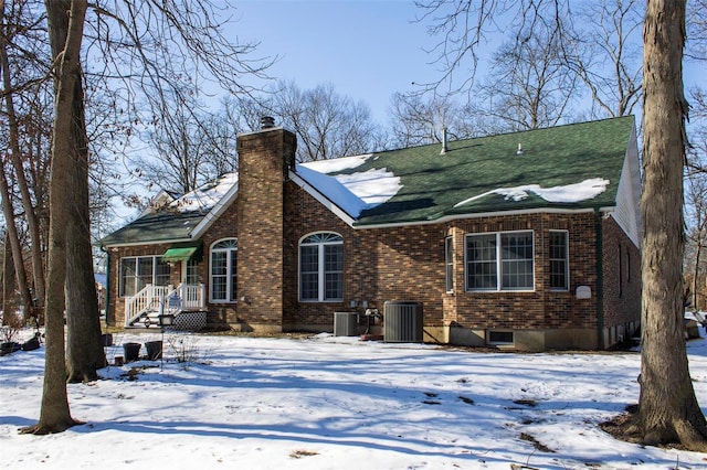 snow covered back of property with central air condition unit