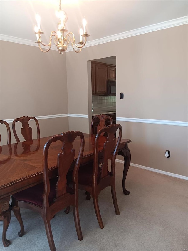 dining room with crown molding, carpet floors, and a notable chandelier