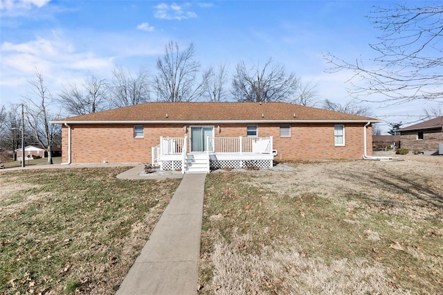 rear view of house featuring a wooden deck and a yard