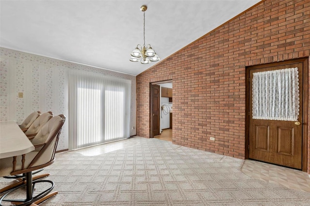 unfurnished office with vaulted ceiling, brick wall, light carpet, and an inviting chandelier